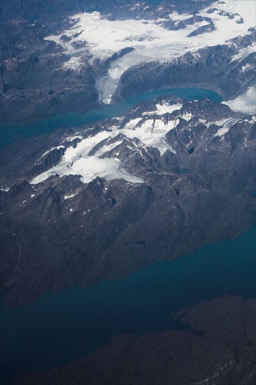 Groenland. Vue aérienne, côte sud-ouest près du Cap Farewell, terre du Roi Frédéric VI, (été 2008, 9000 m d'altitude) montagnes enneigées, glaciers, fjords et icebergs