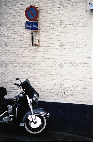 Bruges. Moto dans les ruelles de la ville médiévale, après la pluie