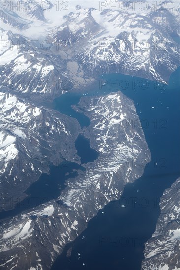 Groenland. Vue aérienne, côte sud-est près du Cap Farewell, terre du Roi Frédéric VI, (été 2008, 9000 m d'altitude) montagnes enneigées, glaciers, fjords et icebergs
