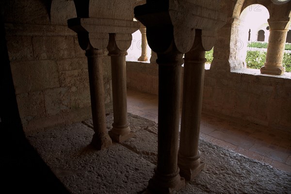 Provence810 Abbaye du Thoronet, le cloître vu depuis la salle capitulaire : arcades géminées, oculus et chapiteaux, vue sur le jardin du cloître