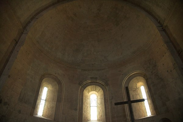 Provence827 Abbaye du Thoronet : intérieur de l'église (chœur en abside voûtée formant la moitié d'une coupole, trois fenêtres en plein cintre symbolisant la Trinité, croix)