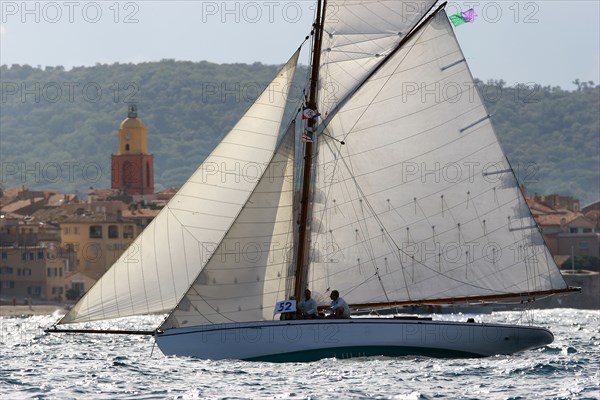 Yacht de tradition devant un village