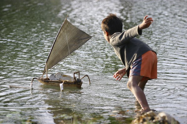 Un enfant de pêcheur joue avec son bateau