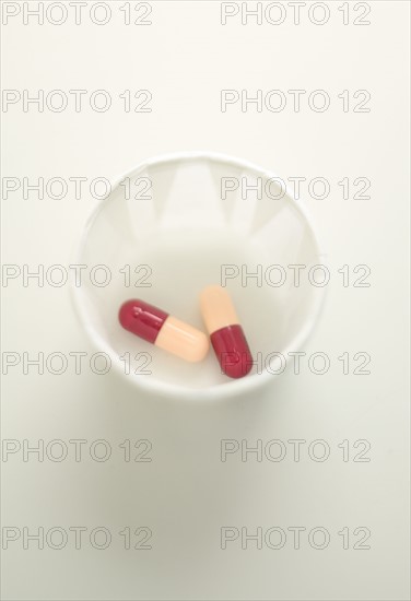 Medical capsules in a cup.