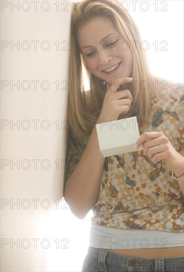 Young female reading a note.
