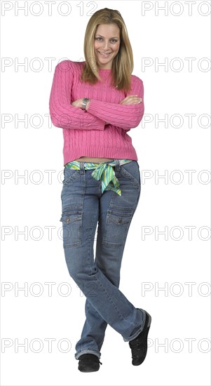 A young woman standing with her arms folded.