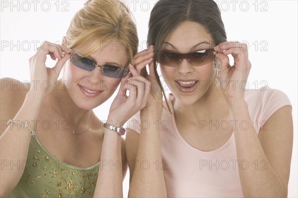 Women putting on sunglasses.