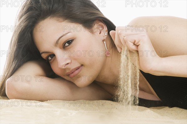 Woman sifting sand through fingers.