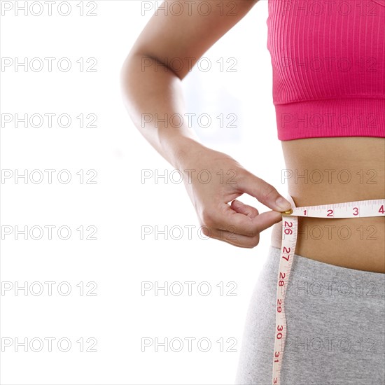 Woman measuring waistline.