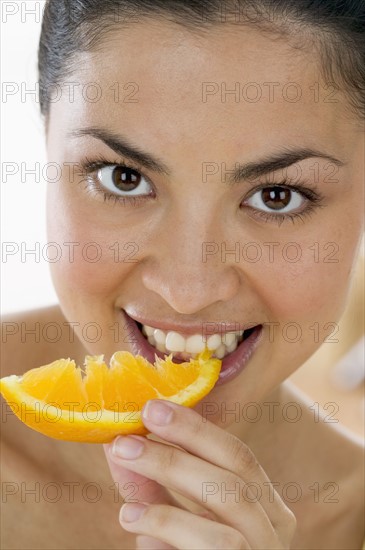 Woman eating orange.