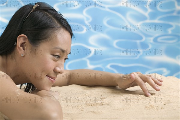 Woman lying on sand.