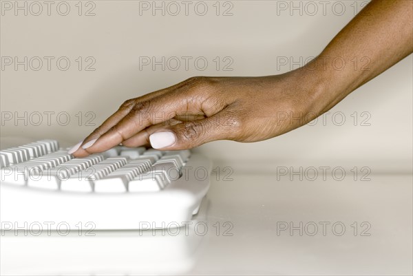 A woman's hand on computer keyboard.