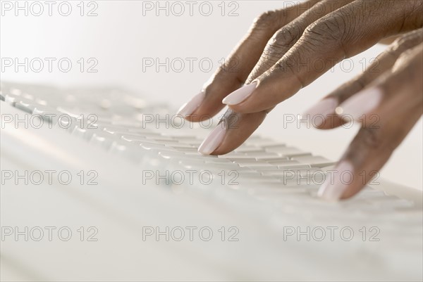 Woman's hands on a computer keyboard.