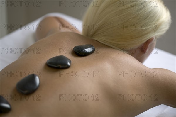 Woman receiving a hot rock treatment.