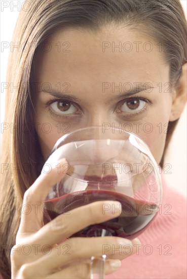 A woman sipping red wine.