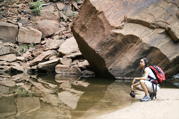 Female backpacker relaxing at a mountain lake.