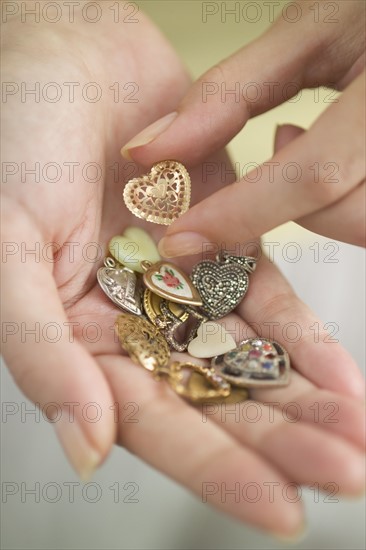 Woman holding a handful of hearts-shaped vitamins.