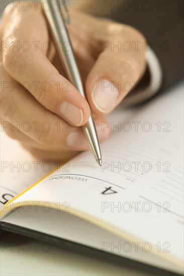 Man writing in an appointment book.