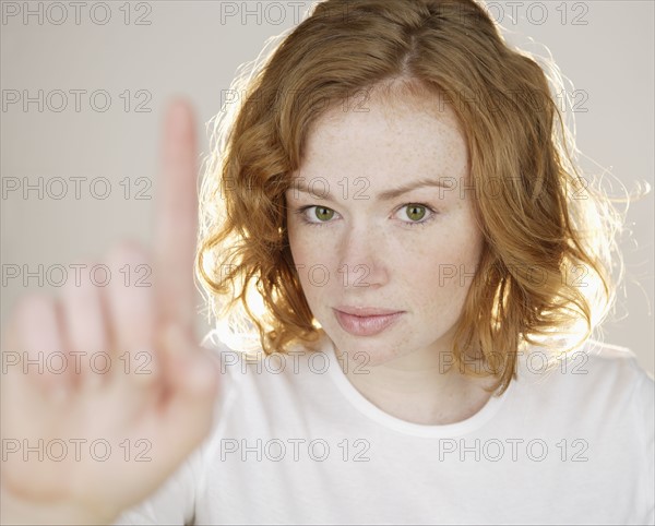 Redhead holding up one finger.