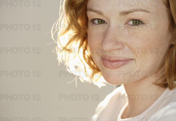 Portrait of smiling redheaded woman.