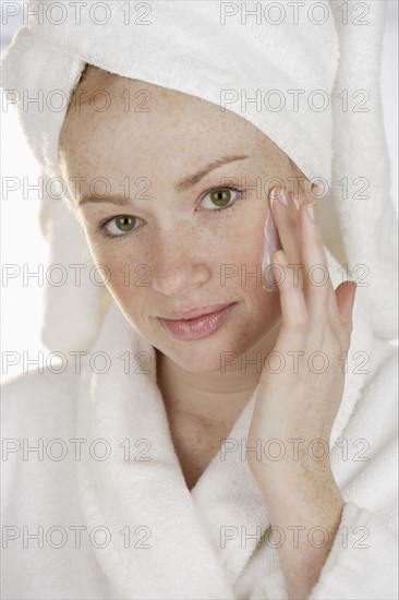 Woman applying face cream.