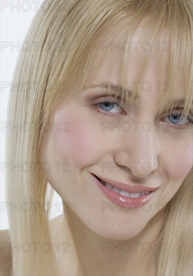 Headshot of woman with coy smile.