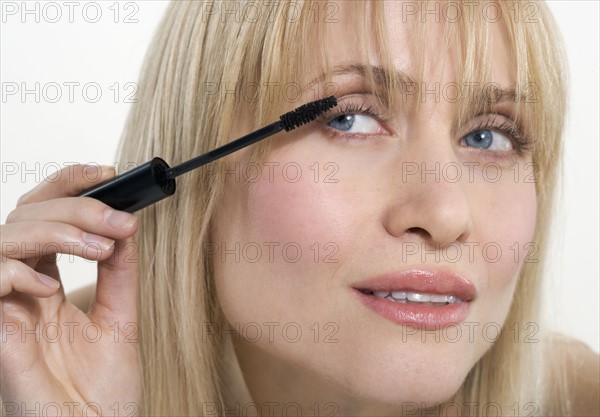 Woman applying mascara.