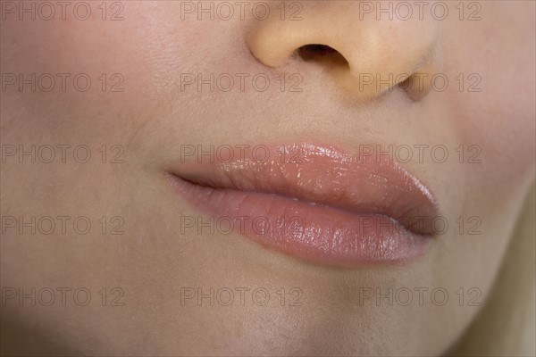 Closeup of woman's lips and nose.