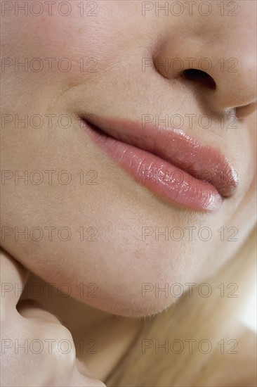 Closeup of woman's mouth and hand.