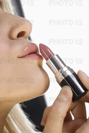 Profile of lips with lipstick tube.