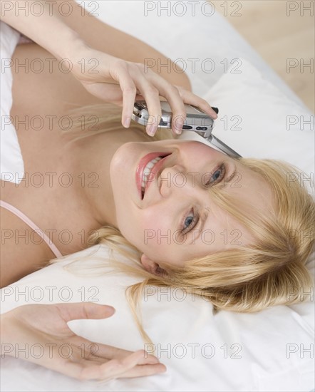 Woman lying down talking on mobile phone.