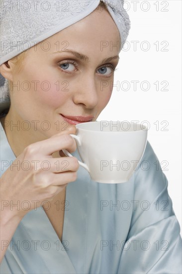 Woman in bathrobe with coffee cup.