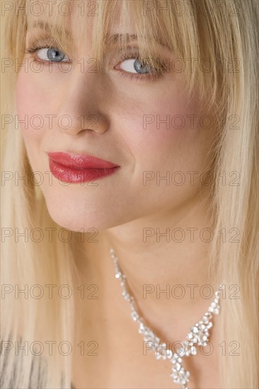 Smiling woman wearing necklace.