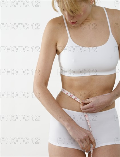 Woman measuring her waist.