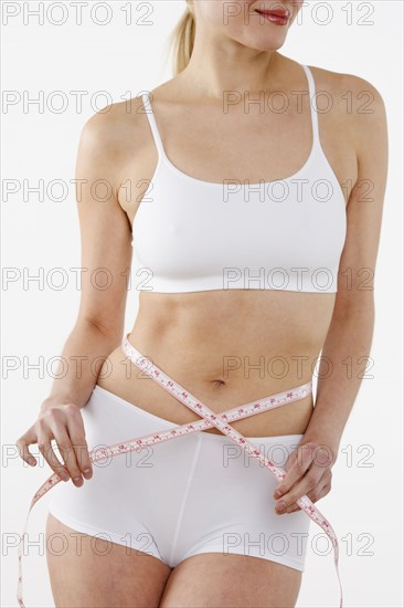 Woman's torso encircled by tape measure.