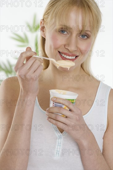 Woman eating cup of yogurt.
