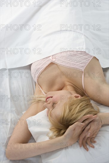 Profile of smiling woman in bed.