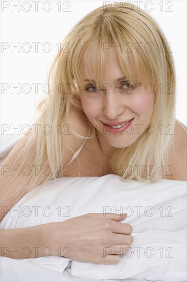 Portrait of smiling woman on pillow.