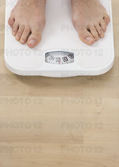 Female feet on bathroom scale.