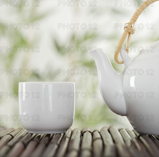 Teapot and cup on bamboo.