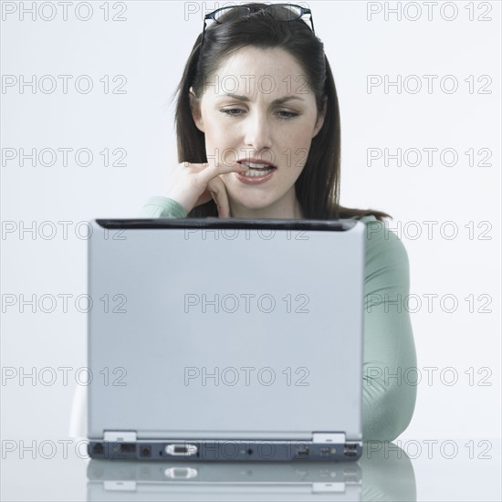 Woman thinking with laptop.