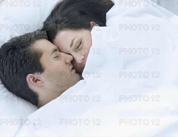 Couple asleep in bed.