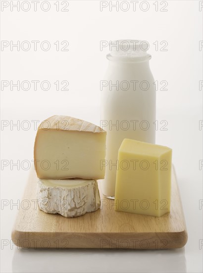 Cheese and milk on cutting board.