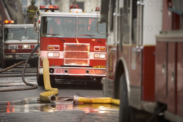 Firetrucks parked with hoses.