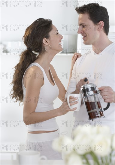 Laughing young couple with coffee.