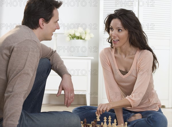 Couple talking and playing chess.