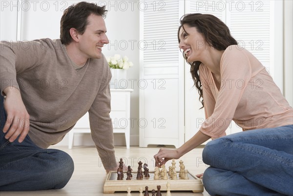 Smiling couple playing chess.