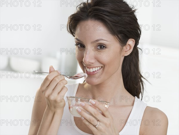 Smiling woman with dish and spoon.