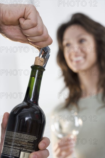 Uncorking bottle of wine.