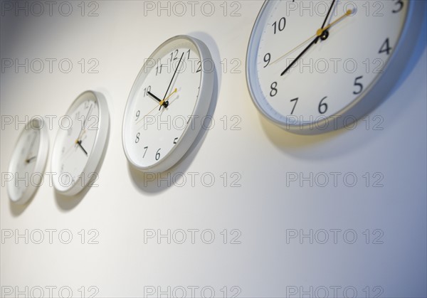 Closeup of clocks telling different times.